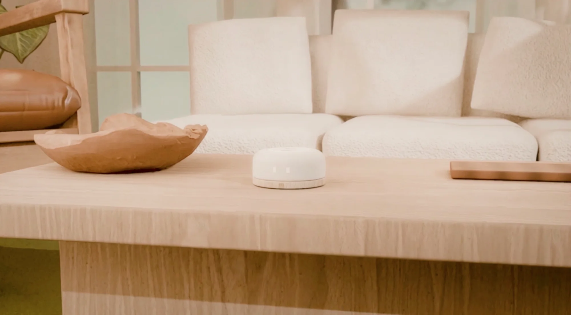 Hushpup on a pale oak coffee table in a calm living room with a boucle sofa.